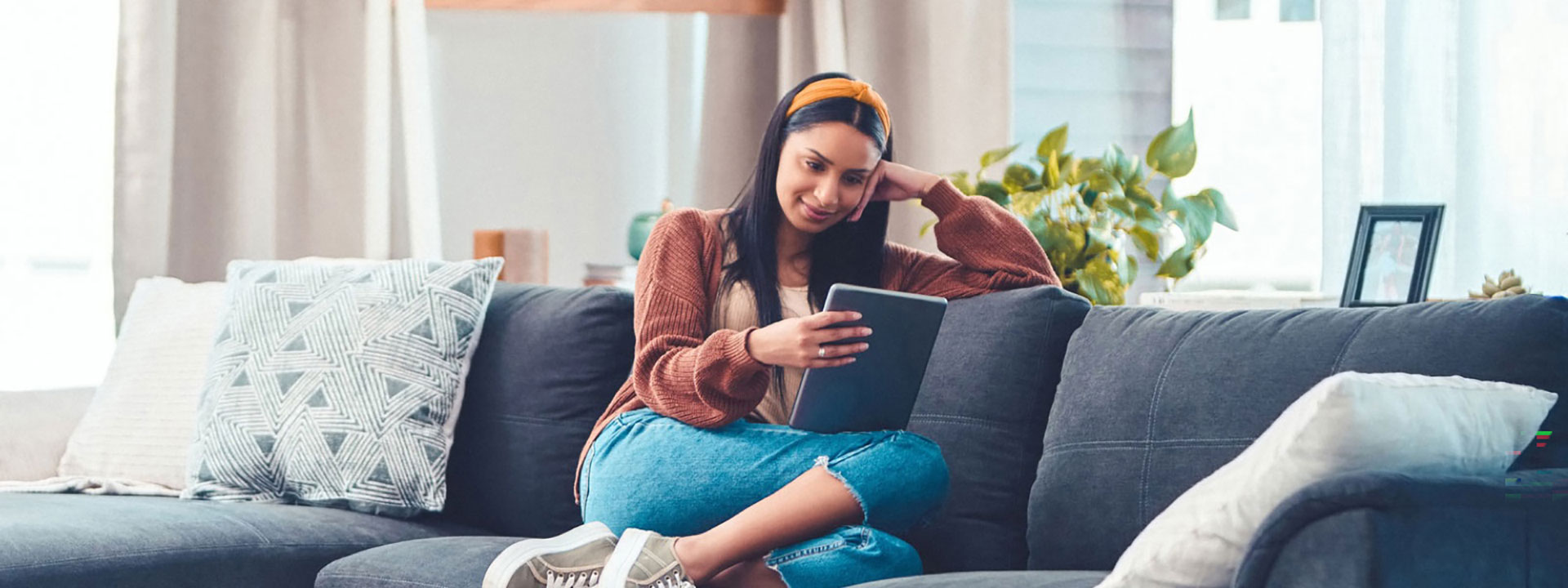 Woman reading news on tablet on sofa